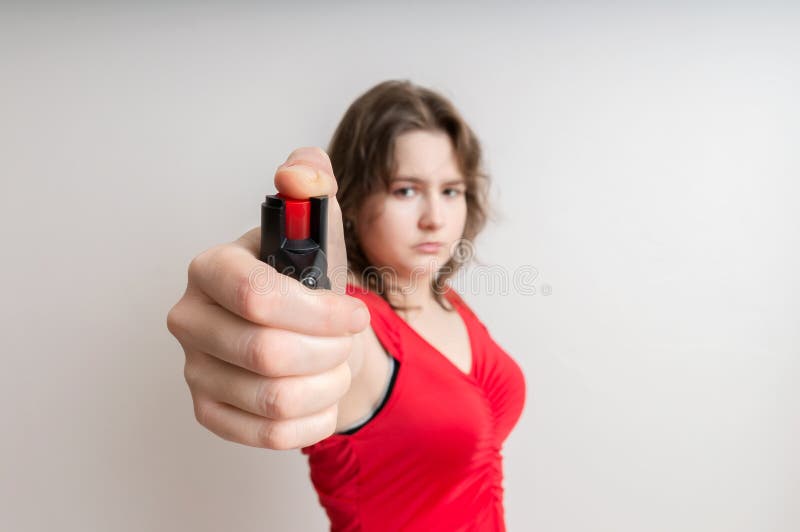 Young woman holds pepper spray in hand. Self defense concept
