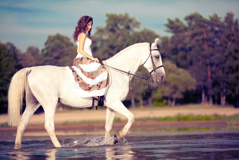 Young woman on a horse. Horseback rider, woman riding horse on b