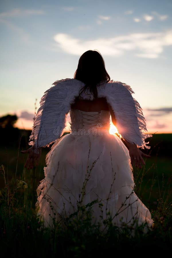 A Young Woman in the Image of the Angel Stands on a Hill with Raised ...