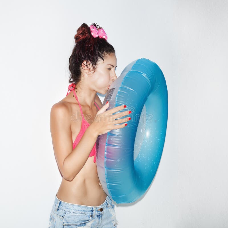 Young woman inflating an inner tube. 