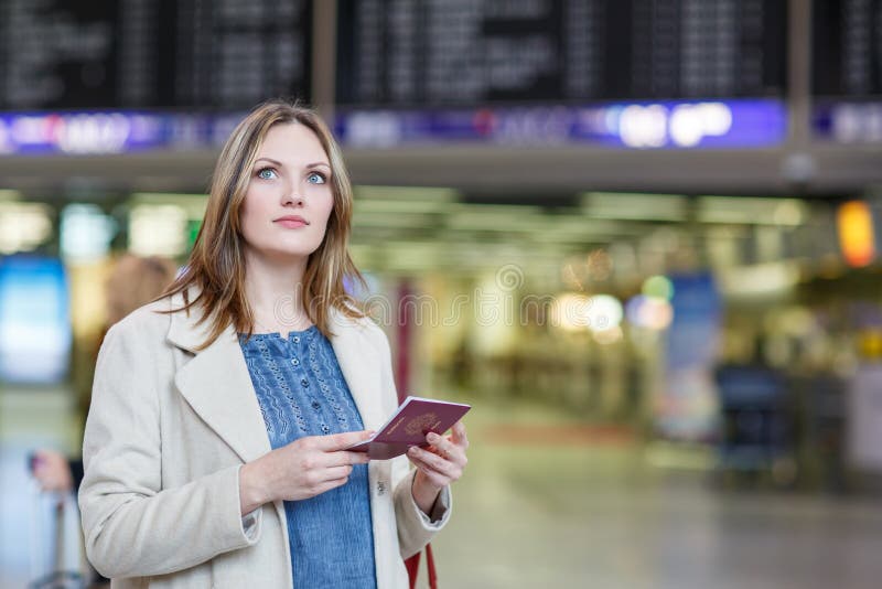 Young woman at international airport, checking electronic board