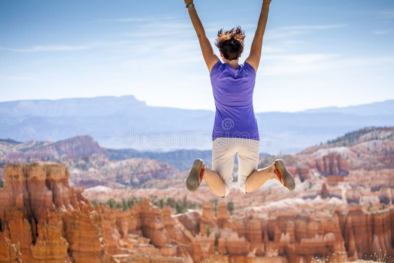 Young woman joyfully jumping in Bryce Canyon Park royalty free stock photography Young woman joyfully jumping in Bryce Canyon Park royalty free stock photography