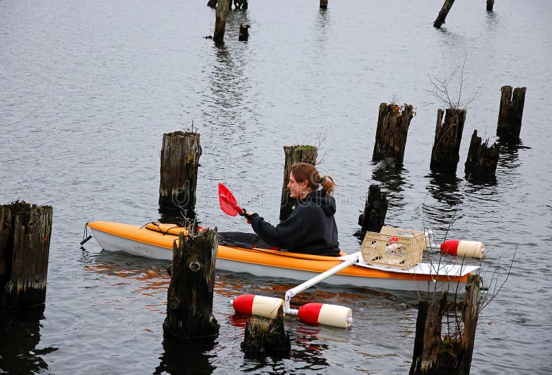 Young Woman Kayaks In Pilings stock photo Young Woman Kayaks In Pilings stock photo