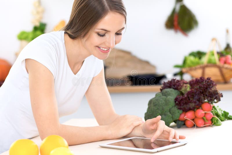 Young Woman at the Kitchen Making Online Shopping by Tablet Computer