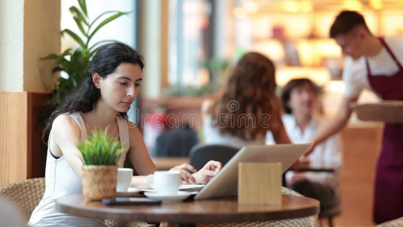 Young woman with laptop drinking coffee stock video