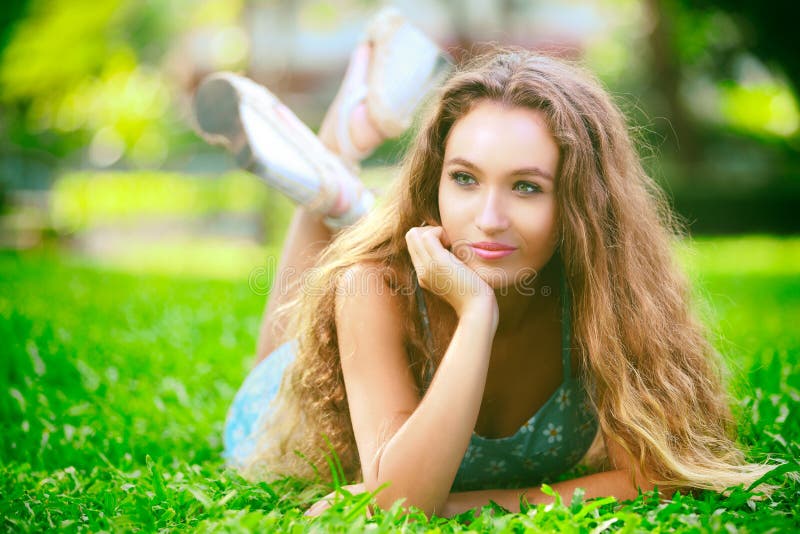 Young woman laying on green grass