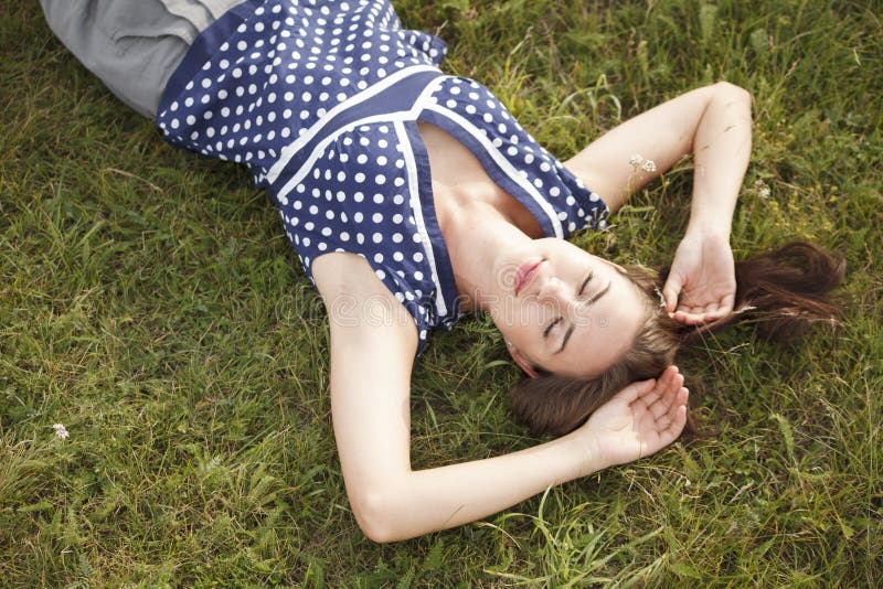 Young woman lies on the grass stock photography