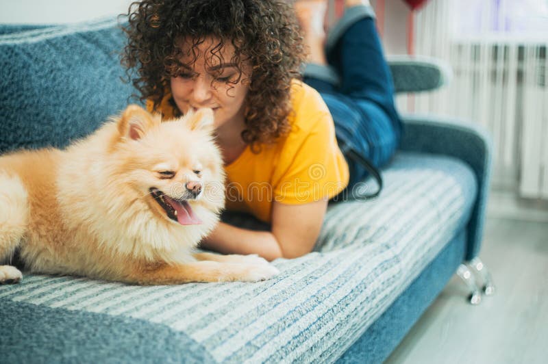 Young Woman Listening To Music in Headphones, a Dog Lies Nearby Stock