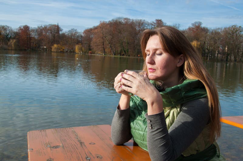 Esterno casuale ritratto giovane donna potabile tè pace Umore un chiuso occhi mentre sul costa autunno da monaci germania.