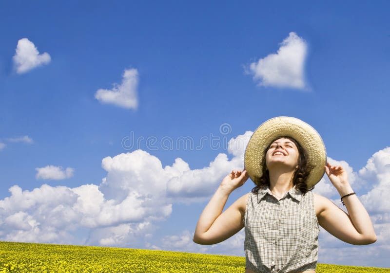 Young woman looking at heart shaped clouds