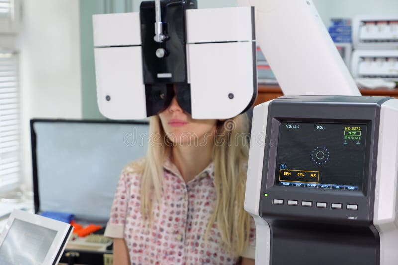 Young woman looking at refractometer eye test machine in ophthalmology stock photos Young woman looking at refractometer eye test machine in ophthalmology stock photos