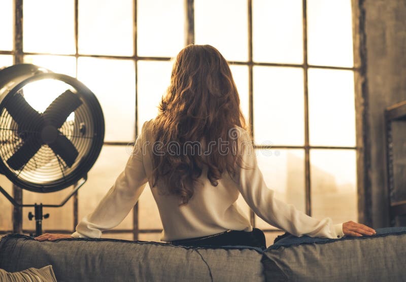 Young woman looking in window in loft apartment