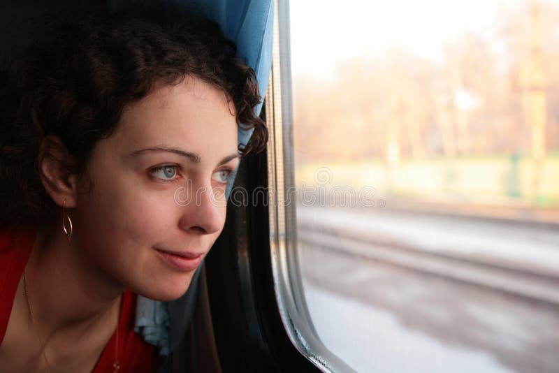 Young woman looks in train`s window