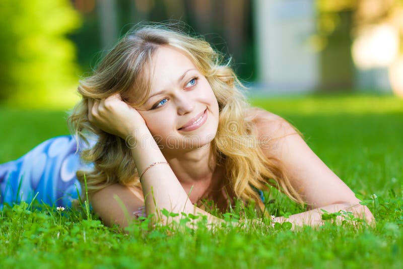 Young woman lying on a green grass