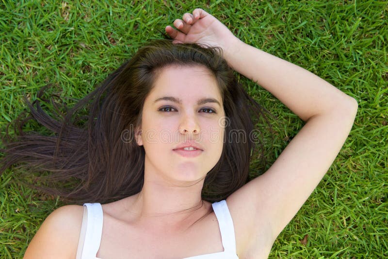 Young woman lying on green grass