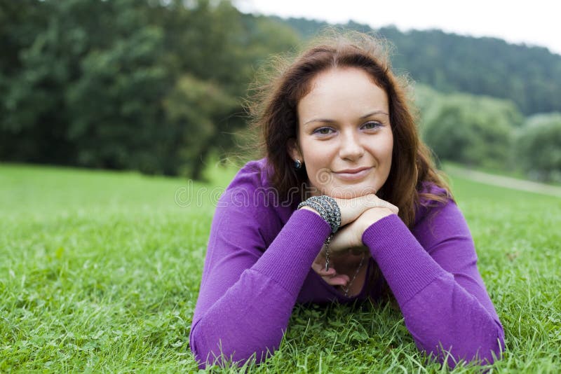 Young woman lying on a green lawn