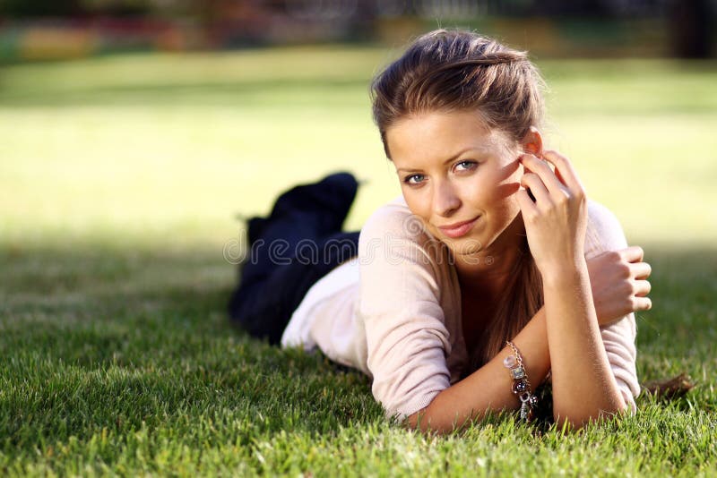 Young woman lying on a green lawn