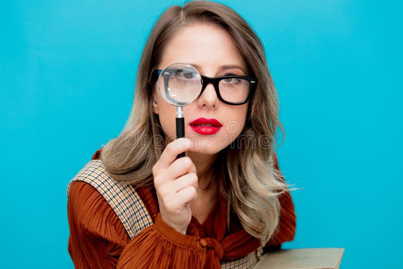 Young woman with magnifier and books