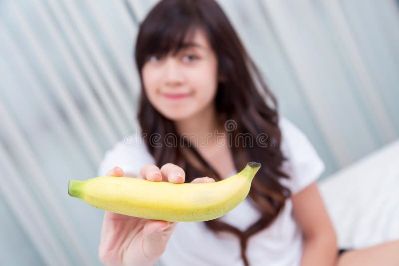 Young Woman Making Fun With A Banana On Her Bedroom Concept For