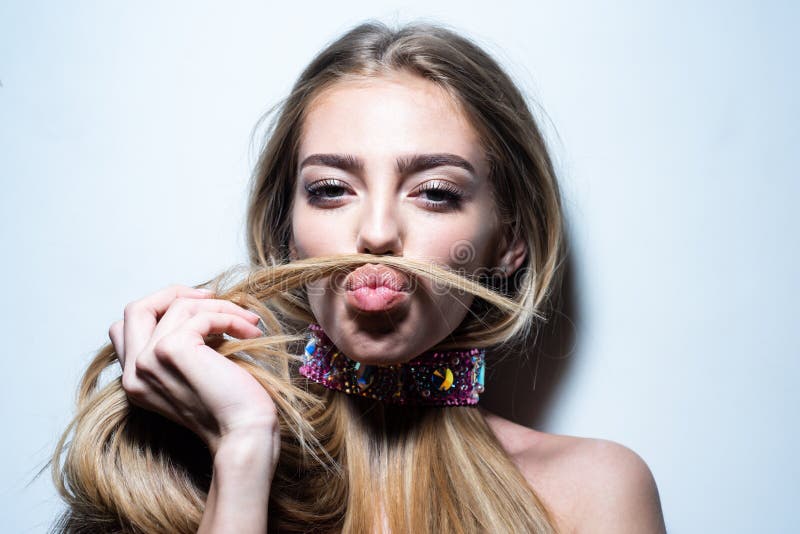 Young woman making mock moustache with her hair. Gorgeous seductive model girl with long hair. Beauty girl, beautiful