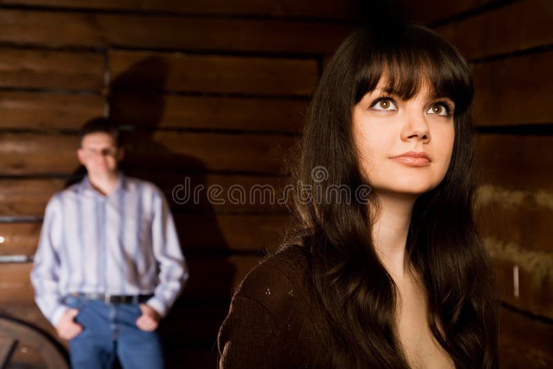 Young woman and man in wooden log hut