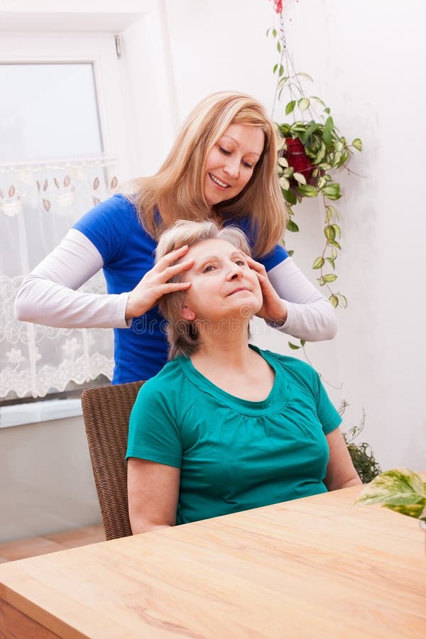 Blond Young women massaging female seniors scalp. Blond Young women massaging female seniors scalp