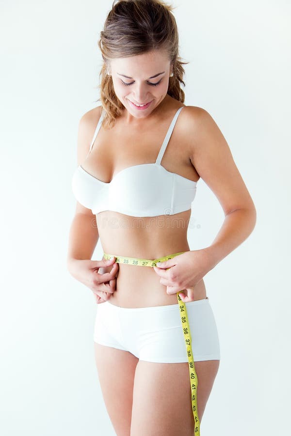 Young woman measuring her waist by measure tape.