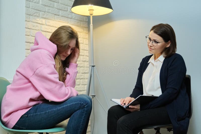 Young women in meeting with female psychologist, girl student telling her problems therapist, mental health of youth. Young women in meeting with female psychologist, girl student telling her problems therapist, mental health of youth