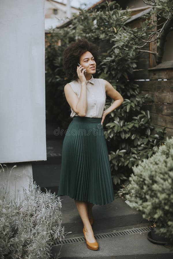 Young woman with a mobile phone in his hand standing in the backyard stock photos Young woman with a mobile phone in his hand standing in the backyard stock photos