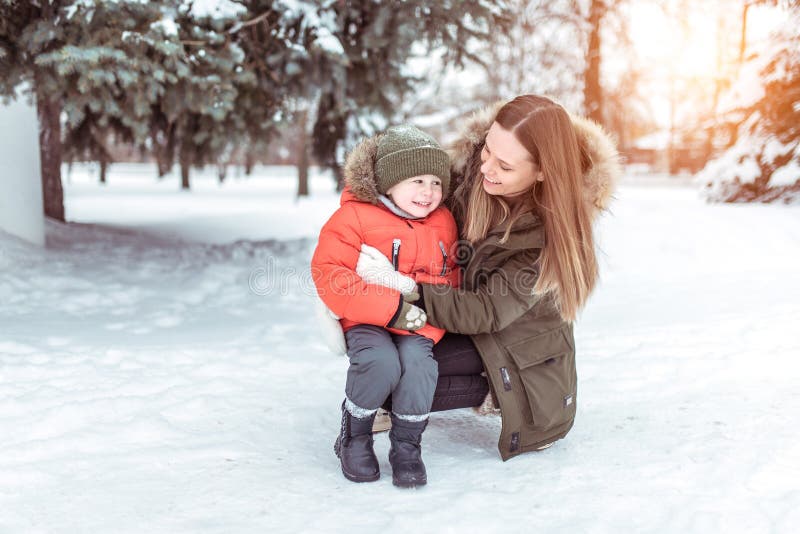 Young woman mother winter street, plays with her young son boy 3 years. Happy smiling, weighing up, laughing rejoicing royalty free stock image Young woman mother winter street, plays with her young son boy 3 years. Happy smiling, weighing up, laughing rejoicing royalty free stock image