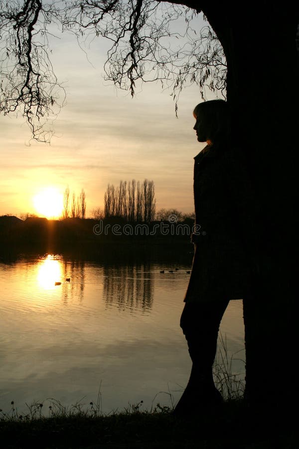 Young woman near lake at sunset