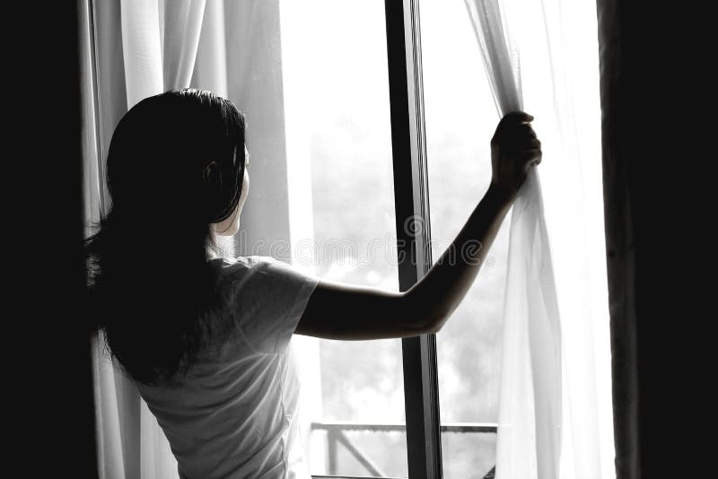 Young woman open window and curtains with sunshine morning