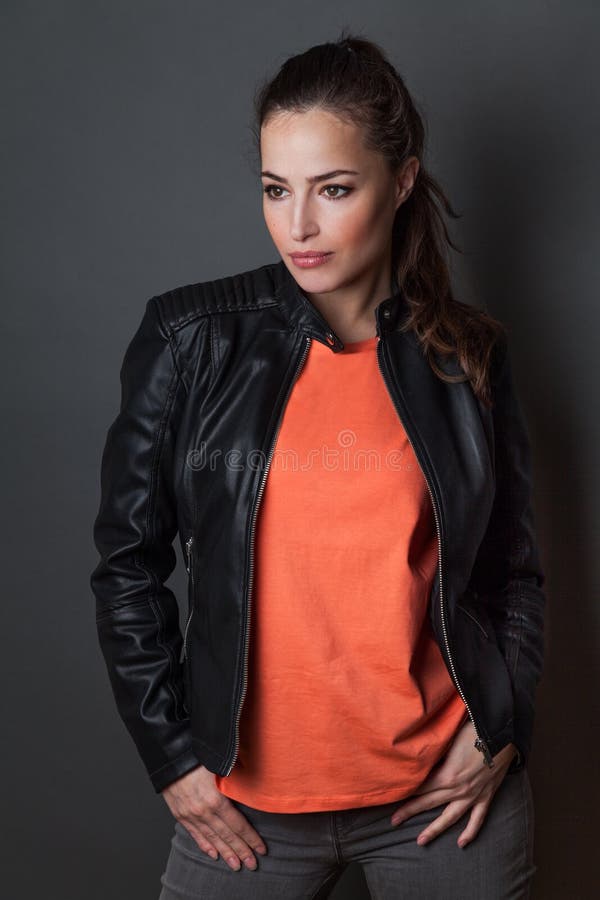 Young woman in orange  t-shirt and black leather jacket  studio shot,  t shirt mock up royalty free stock image