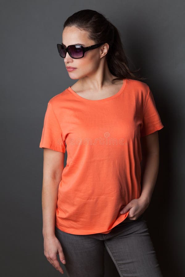 Young woman in orange  t-shirt  and sunglasses studio shot gray background,  t shirt mock up stock photos