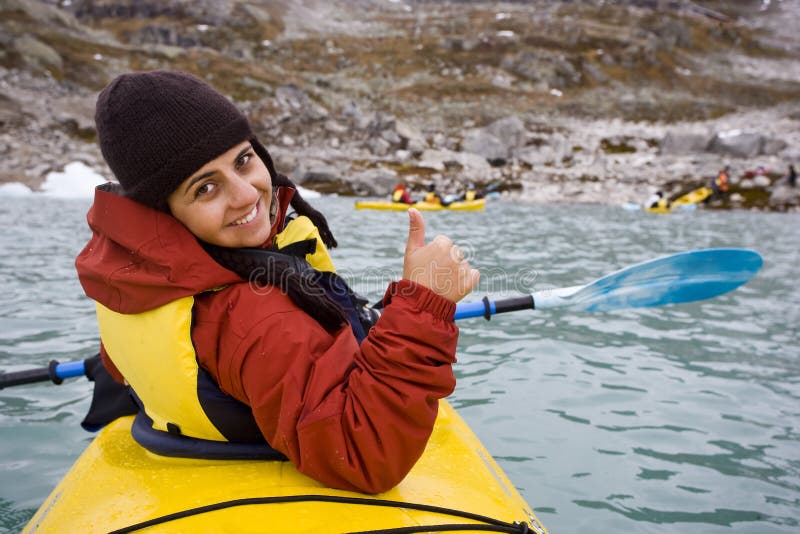 Young woman paddling in yellow kayak