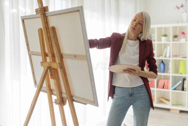 Young woman painting on canvas royalty free stock photos