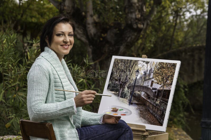 Young woman painting on a park