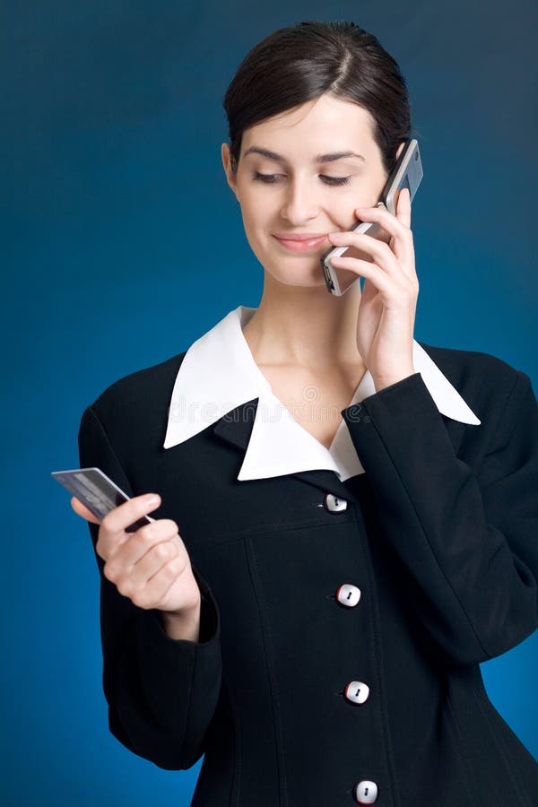 Young woman paying with credit card by phone royalty free stock image