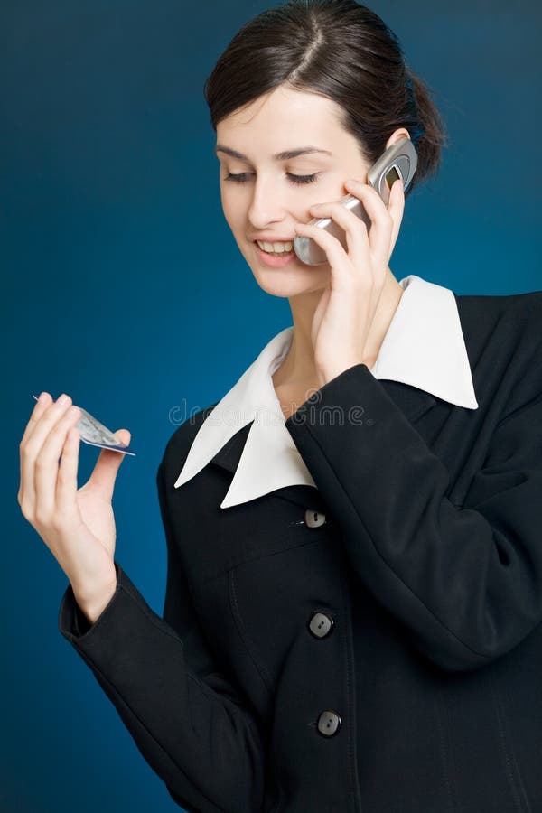 Young woman paying with credit card by phone stock photo