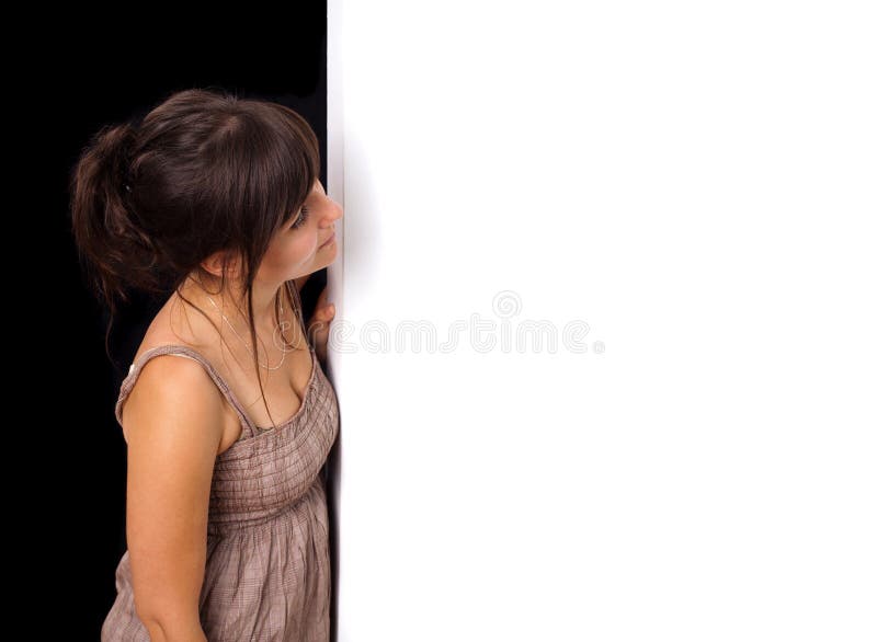A young woman peeking behind wall stock image A young woman peeking behind wall stock image