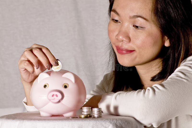 Young woman with pink piggy bank