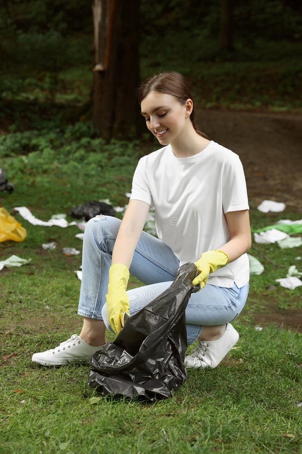 Young Woman with Plastic Bag Collecting Garbage in Park Stock Image