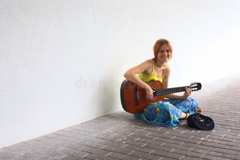Young Woman Playing the Guitar on the Street