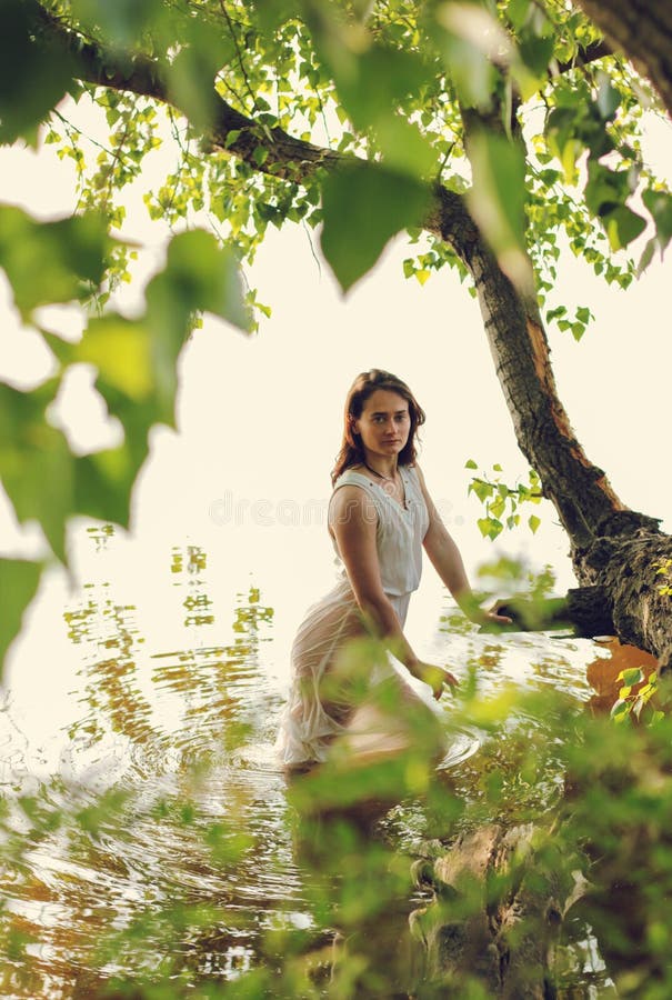 Smiling woman near tree in park - a Royalty Free Stock Photo from Photocase
