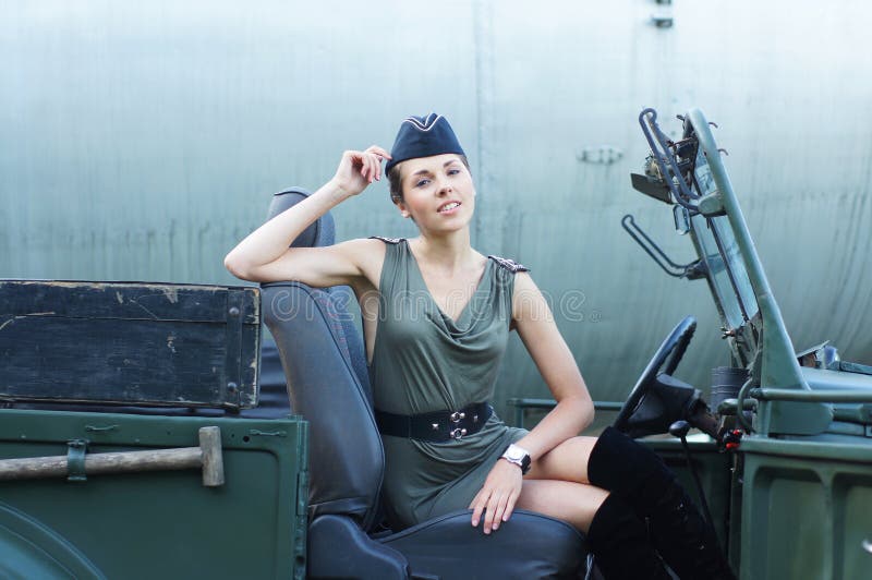 A young woman posing in military clothes in a car