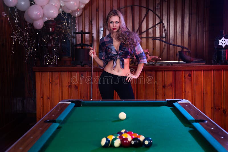 Young woman posing in front of billiard pool table