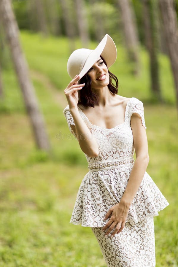 Young woman posing in a white dress with a hat royalty free stock images Young woman posing in a white dress with a hat royalty free stock images