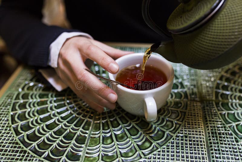 Young woman pouring tea in a cup royalty free stock photo Young woman pouring tea in a cup royalty free stock photo
