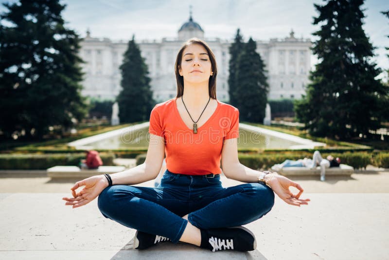 Young woman practicing yoga and meditation in park.Urban relaxation. Female meditating in a public park.Morning routine.Stress. Management concept.Lotus pose royalty free stock images Young woman practicing yoga and meditation in park.Urban relaxation. Female meditating in a public park.Morning routine.Stress. Management concept.Lotus pose royalty free stock images