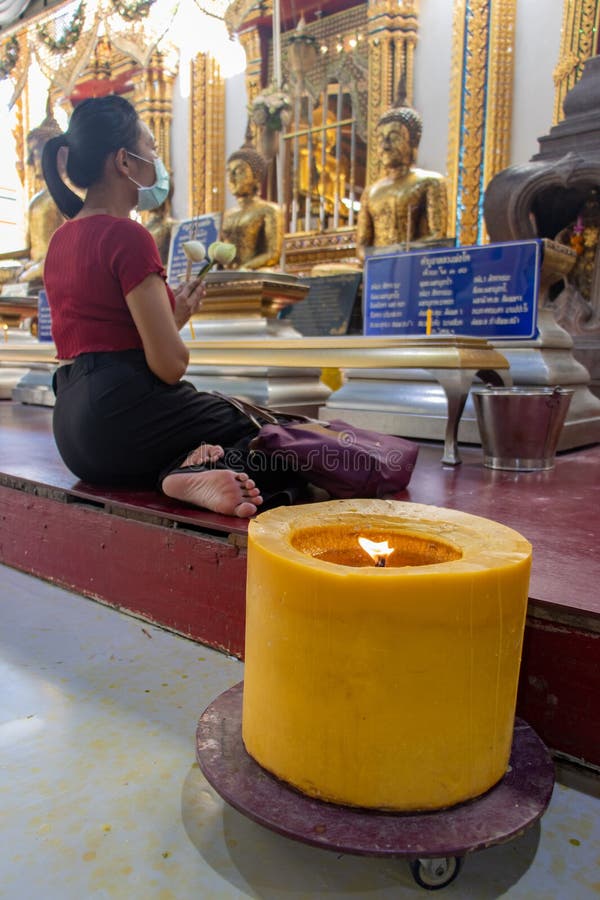A young woman prays in a Buddhist temple, Thailand royalty free stock image